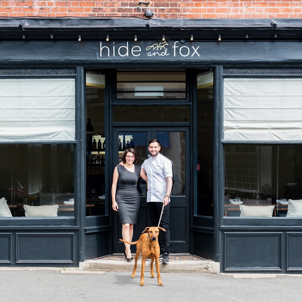 Exterior of Hide and Fox, a two Michelin star restaurant in Saltwood, Kent, with owners shown outside the entrance.