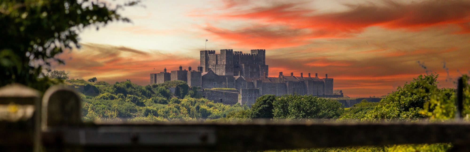 Dover Castle glowing in the early morning sunrise, overlooking the English Channel