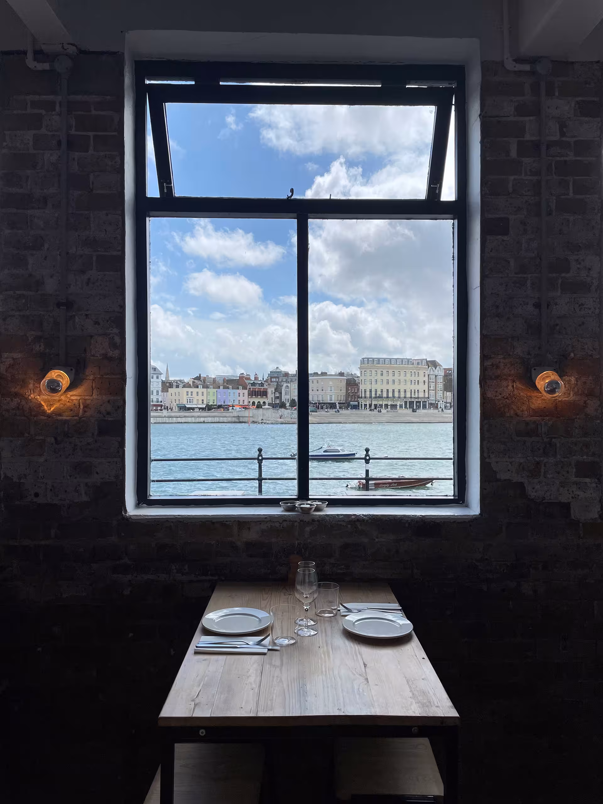A table at Sargasso, perfectly set against a stunning view of the harbour and the colourful seafront beyond.