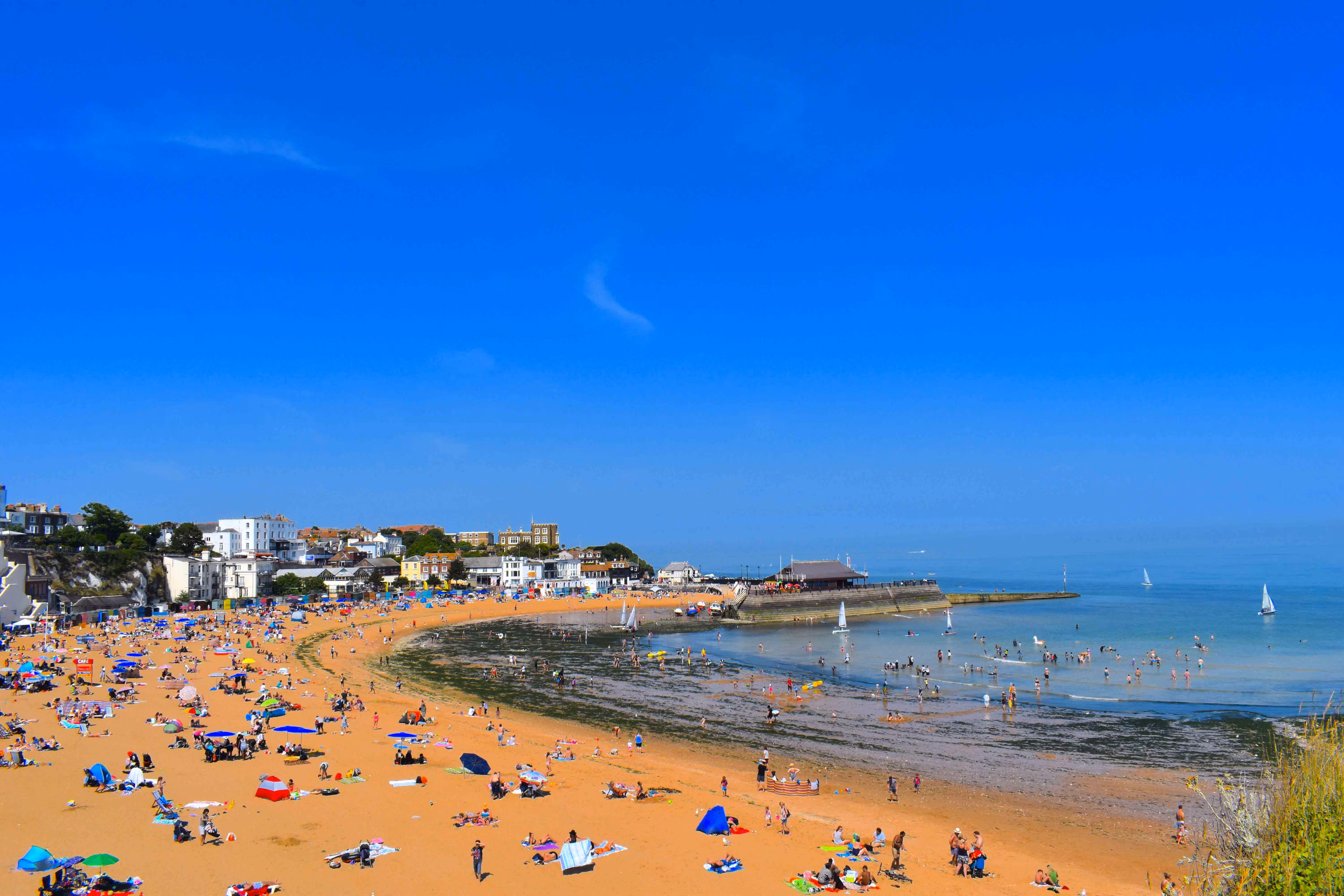 Crowds enjoying the golden sands and clear waters of Viking Bay Beach in Broadstairs, Kent.