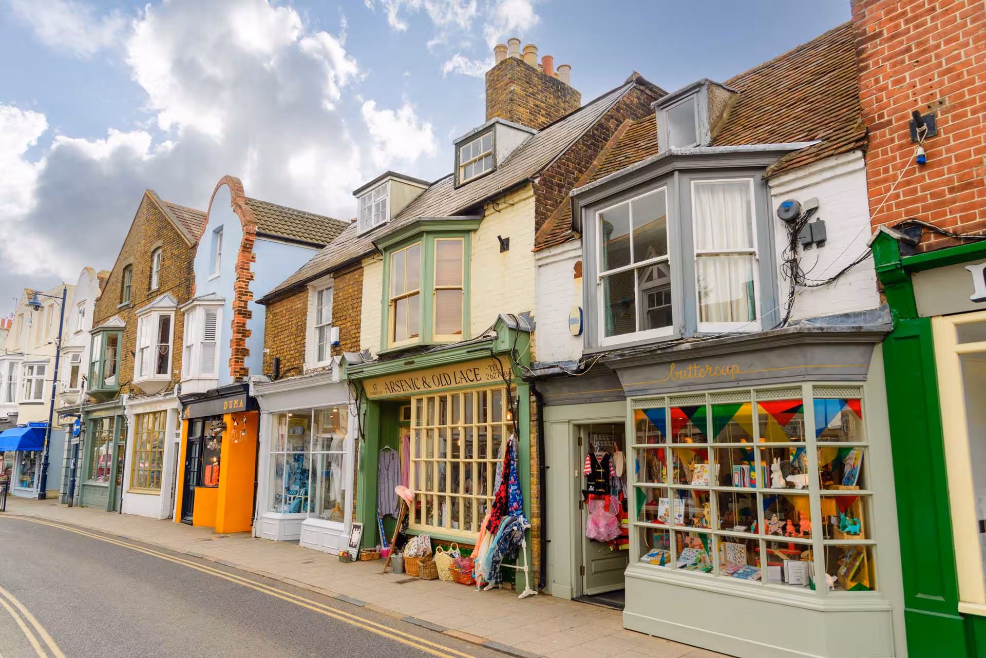 Independent shops and colourful storefronts along Harbour Street in Whitstable, Kent.
